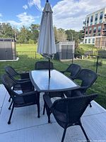 Full view of patio table, six chairs, and umbrella