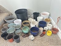 All 33 assorted pots arranged on floor, full lot overview