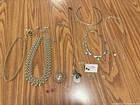 Overall view of necklaces, earrings, pendants, ring and hairpin laid out on table