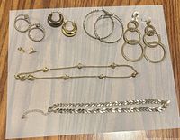All jewelry pieces laid out: five earring pairs and two necklaces