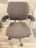 Front view of Humanscale Freedom chair showing seat, backrest, armrests and base.