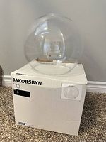 Box labelled JAKOBSBYN with clear glass globe resting on top
