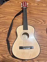 Front overview of mini acoustic guitar with strap