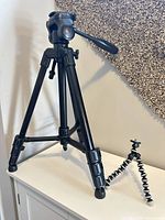 Large black tripod and small flexible mini tripod on cabinet