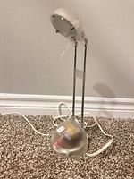 Front angled view of clear IKEA Espressivo lamp showing base, rods, shade and cord