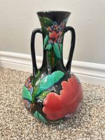 front view of black glazed floral amphora vase with handles