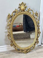 Front view of gold ornate oval mirror showing frame details