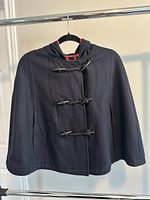 Front view of navy hooded cape with three toggle closures