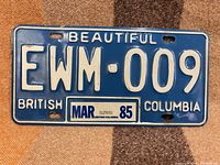Front view of 1985 BC license plate EWM-009 showing color, number, slogan and March 1985 decal