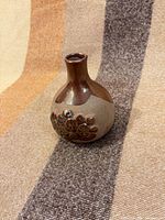 Front view of bud vase showing glaze transition and raised motif