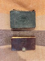 Front view of both small leather books, showing cover designs and clasp