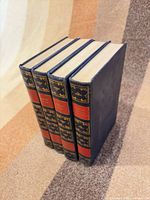 Spine and front view of four matching blue hardcover encyclopedia volumes