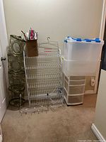 Overview showing white metal rack, plastic drawer tower with tote, hanging mesh organizer, string lights