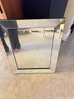 Front view of rectangular mirror showing beveled mirrored frame and central mirror