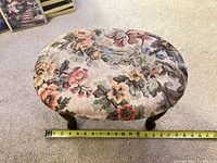 Top view showing floral tapestry upholstery and tape measure indicating length