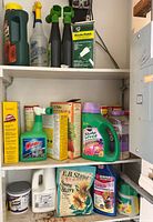 Full view of three-shelf cabinet with assorted cleaning and garden chemical products