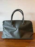 Front view of Estée Lauder green travel bag