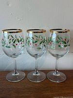 Three Holly pattern wine glasses standing side by side