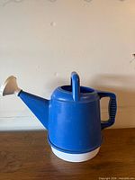 Front view showing blue body, white rose head, top handle and base ring