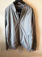 Front view of grey bomber jacket on hanger