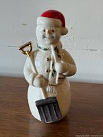 Front view of Lenox snowman figurine showing shovel, scarf, buttons