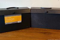 Front view of two black 19-pocket legal file cases showing latch, handle and brand label on one