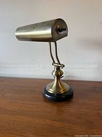 Left side view showing brass cylindrical shade, twin arms, marble base