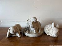 Front view of three cement rabbit figurines