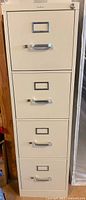 Front view of 4-drawer cream metal file cabinet with chrome handles and top lock