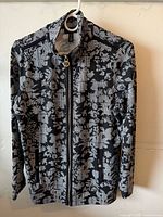 Front view of black and white floral zip jacket