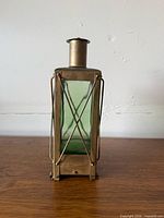Front view of green glass brass-framed lantern decanter