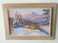 Front view of signed winter mountain cabin oil painting in frame