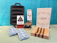 Group shot showing all items: corn roaster, Vinostack box, salad spoons box, coupe glasses box, ice molds, striped board