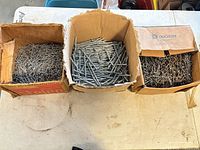 Three boxes filled with assorted nails