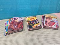 Three stacks of bagged comics on table