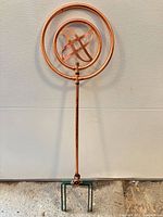 Full view of copper circular sprinkler on stake