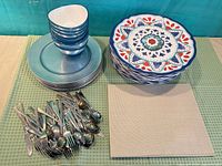overall view of stacked bowls, plates, flatware pile and placemats