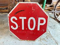 Front view of weathered octagonal stop sign showing lettering, scratches and edge wear
