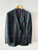 Front view of dark green and navy tartan wool blazer on hanger