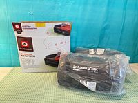 Boxed Outbound two-person double-high air mattress beside one sealed Dukuseek blanket
