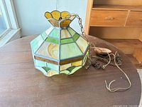 Full view of lamp showing hexagonal body and chain