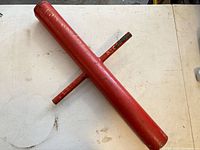 Red steel T-post driver showing full view and handles