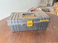 Closed Benchmark tackle box showing brand, latch, wear