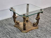 Full view of table showing gold scrolled base and glass top