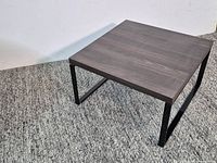 Full view of square coffee table showing wood top and metal legs