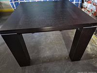 Full view of dark wood dining table showing top and legs