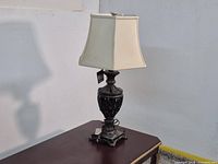 Full view of metal bronze-look table lamp on table