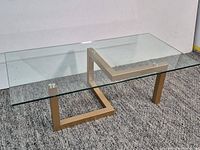 Full view of coffee table showing glass top and gold metal base