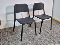 Front view of two black metal stacking chairs