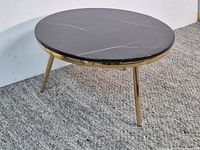 full view of round black marble coffee table on carpet